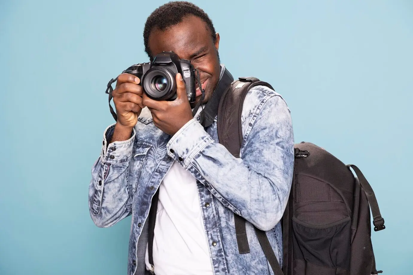 A man concentrating on taking a shot with his camera.